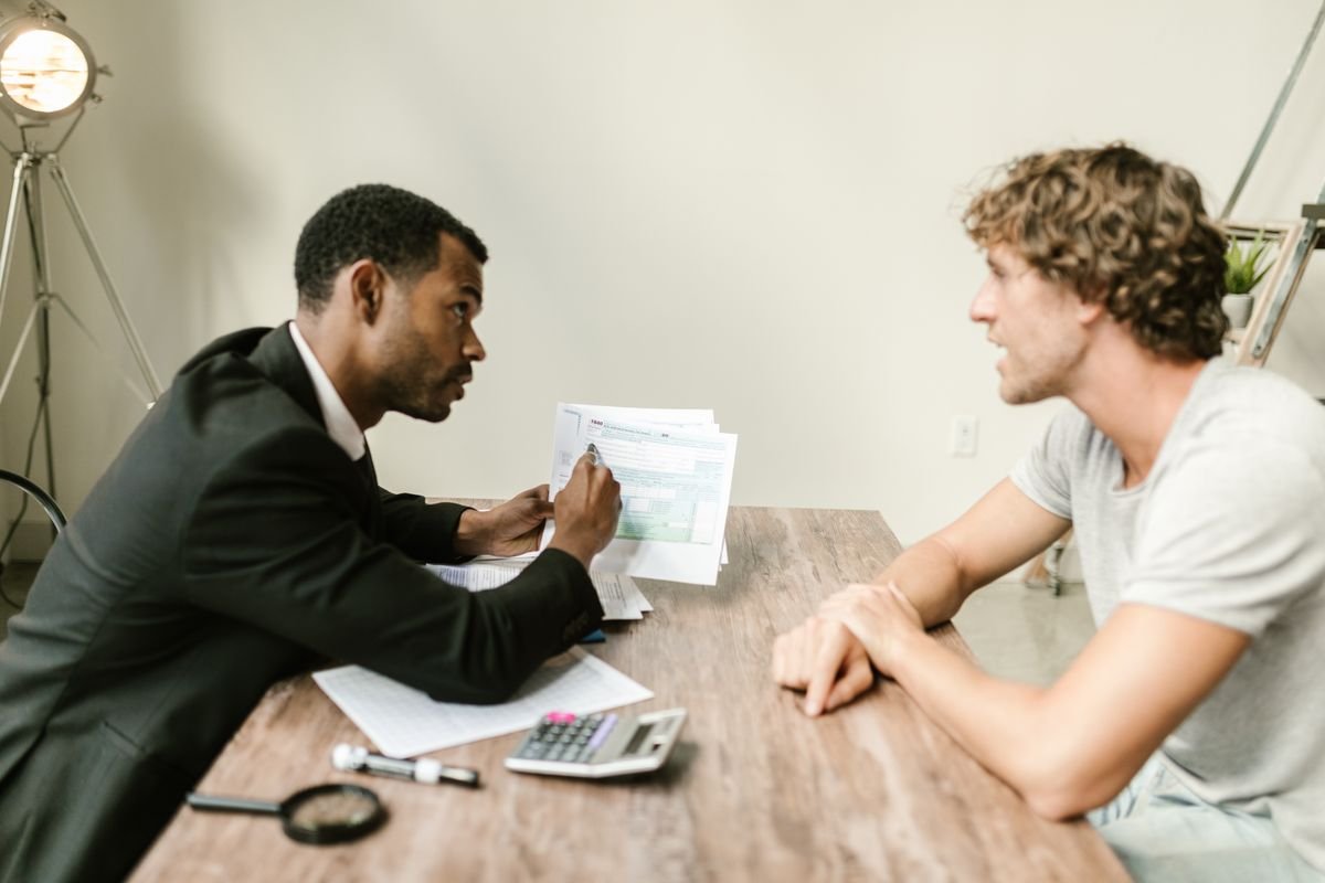 Accountant going through a tax return with a client across a desk — accountants in Guildford, TaxDigit