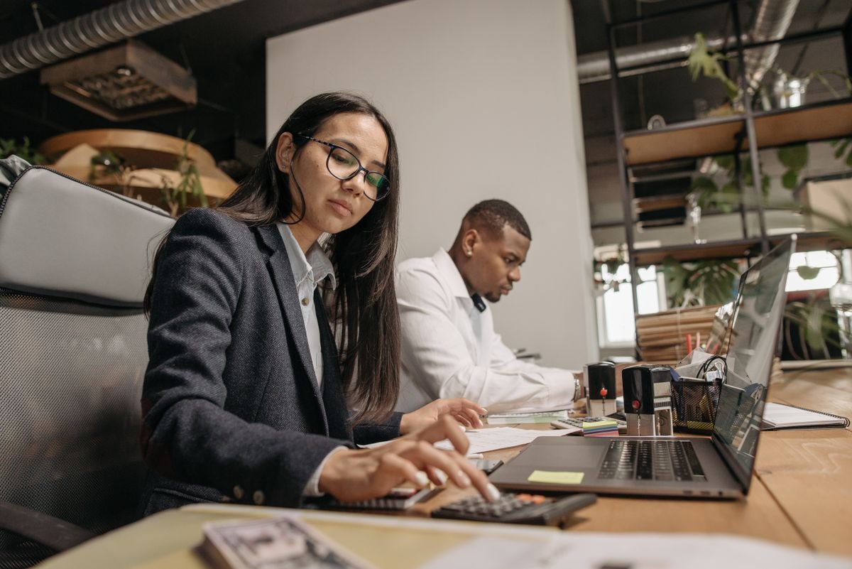 Accountants working through year-end figures on a calculator and laptop — accountants in Guildford, TaxDigit