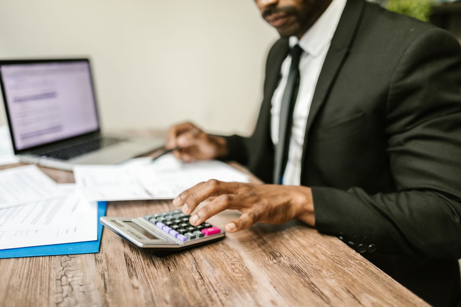 A professional working through documents with a calculator, representing an HMRC disclosure