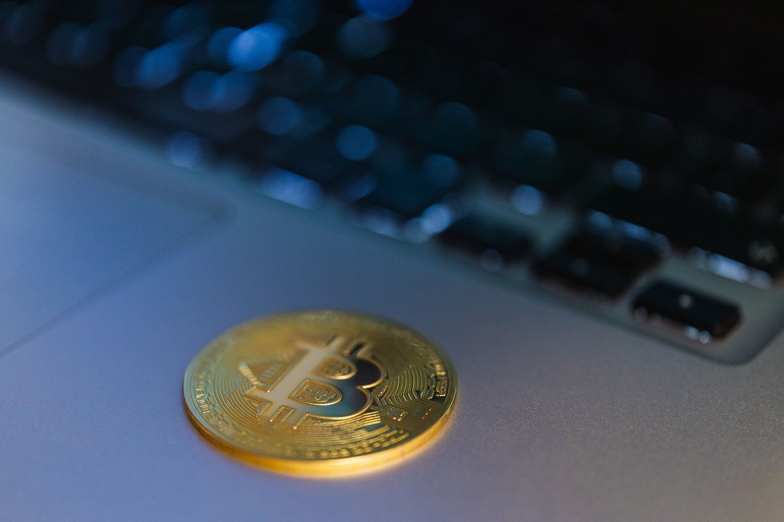 A Bitcoin coin beside a laptop, representing crypto held on a company balance sheet