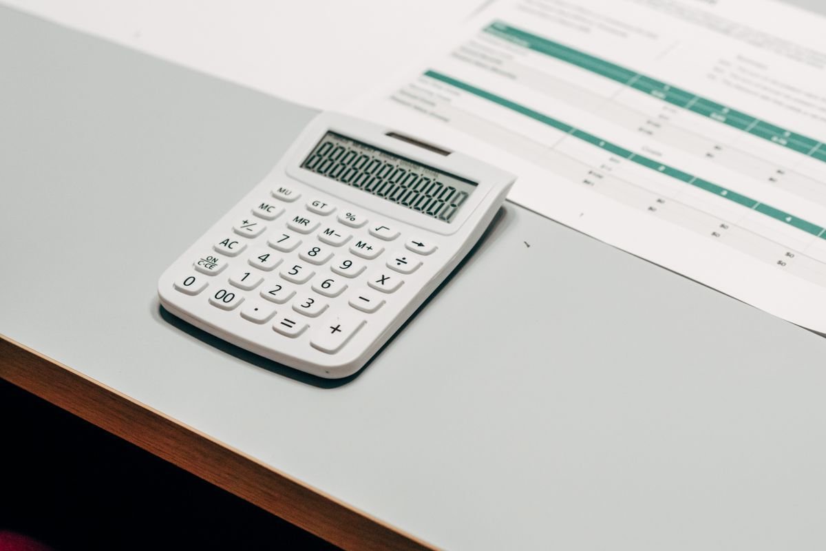 A calculator beside a financial spreadsheet, representing a UK crypto capital gains computation with section 104 pooling