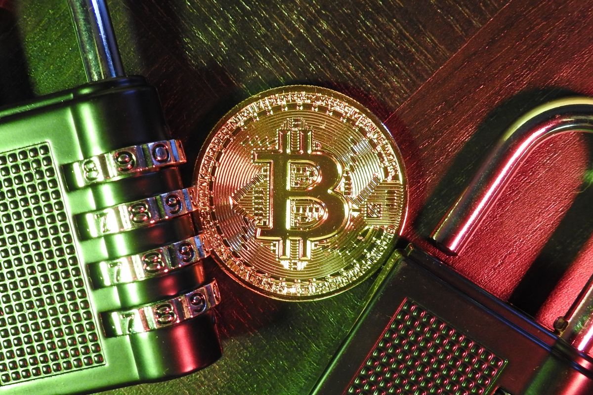 A Bitcoin coin secured with combination padlocks, representing private key custody in a crypto estate