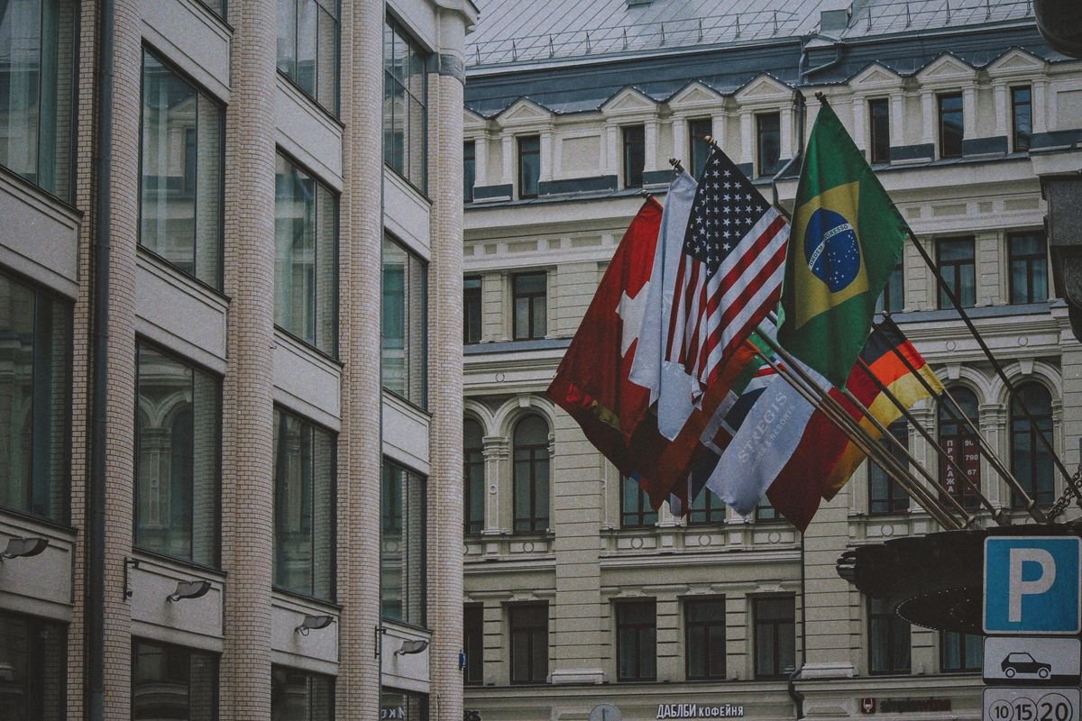 International flags flying outside a modern building, representing how different countries tax cryptoassets in 2026