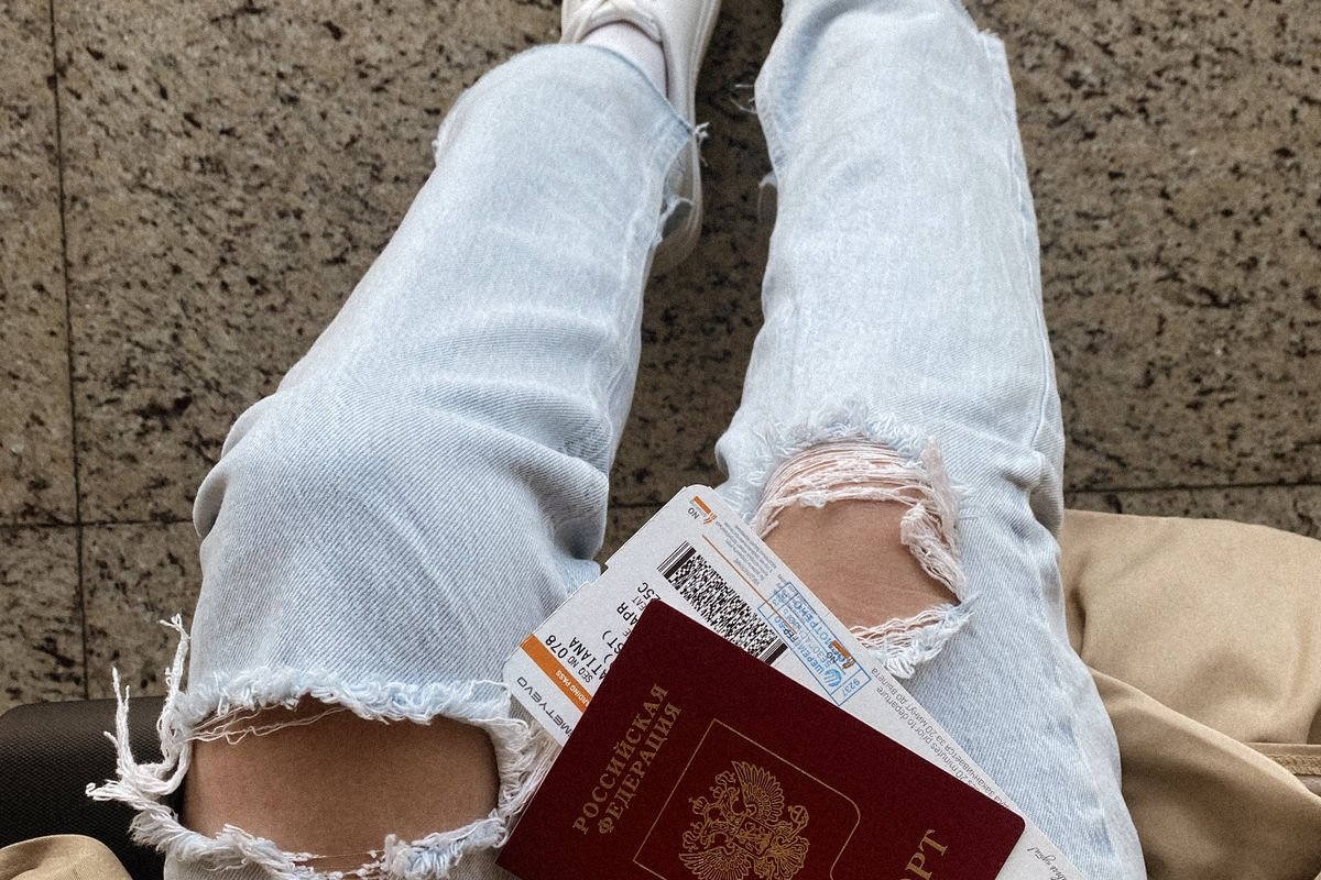 A traveller holding a passport and boarding passes, representing crypto disposals around the date of departure from the UK