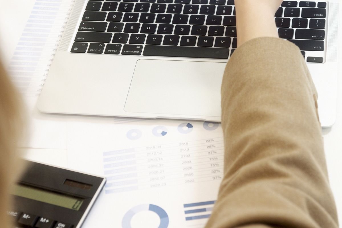 A professional analysing financial data on a laptop, representing reconciliation of crypto tax software output