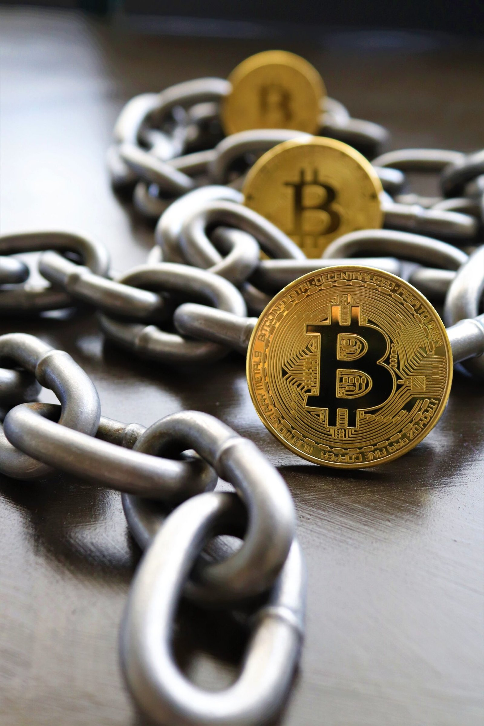 A Bitcoin coin resting against heavy metal chain links, representing crypto lending and collateral