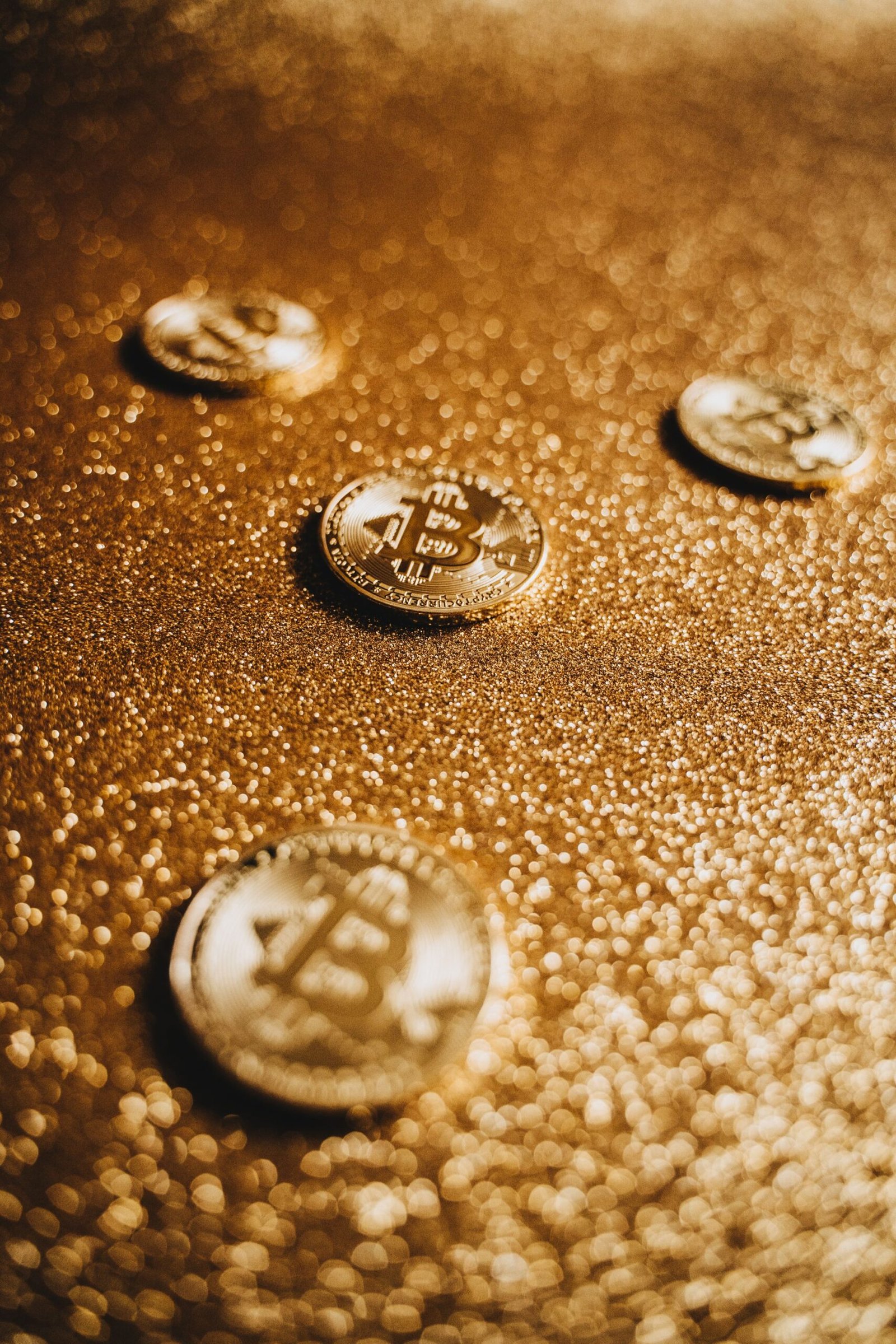 Bitcoin coins on a shimmering gold background