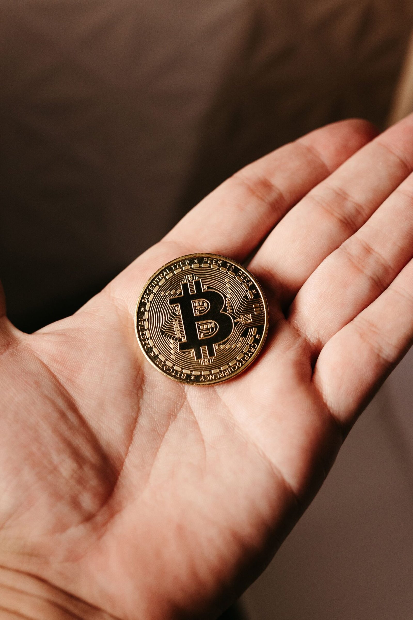 A single Bitcoin coin resting in cupped hands, representing a token received as a reward