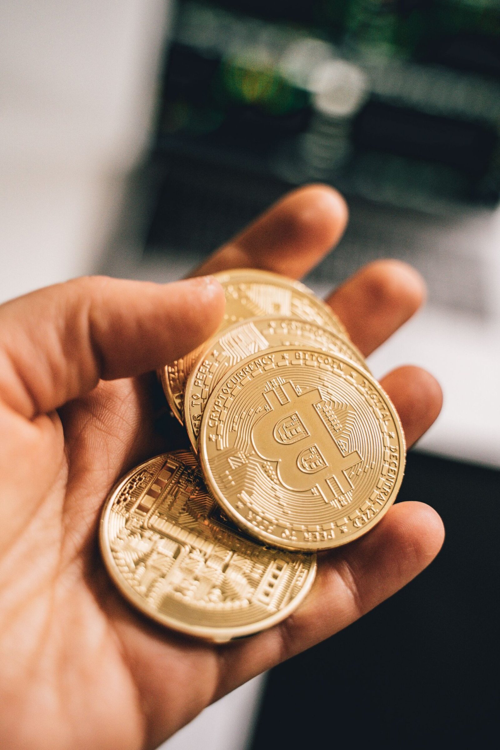 A hand holding several gold crypto coins, representing tokens received without payment