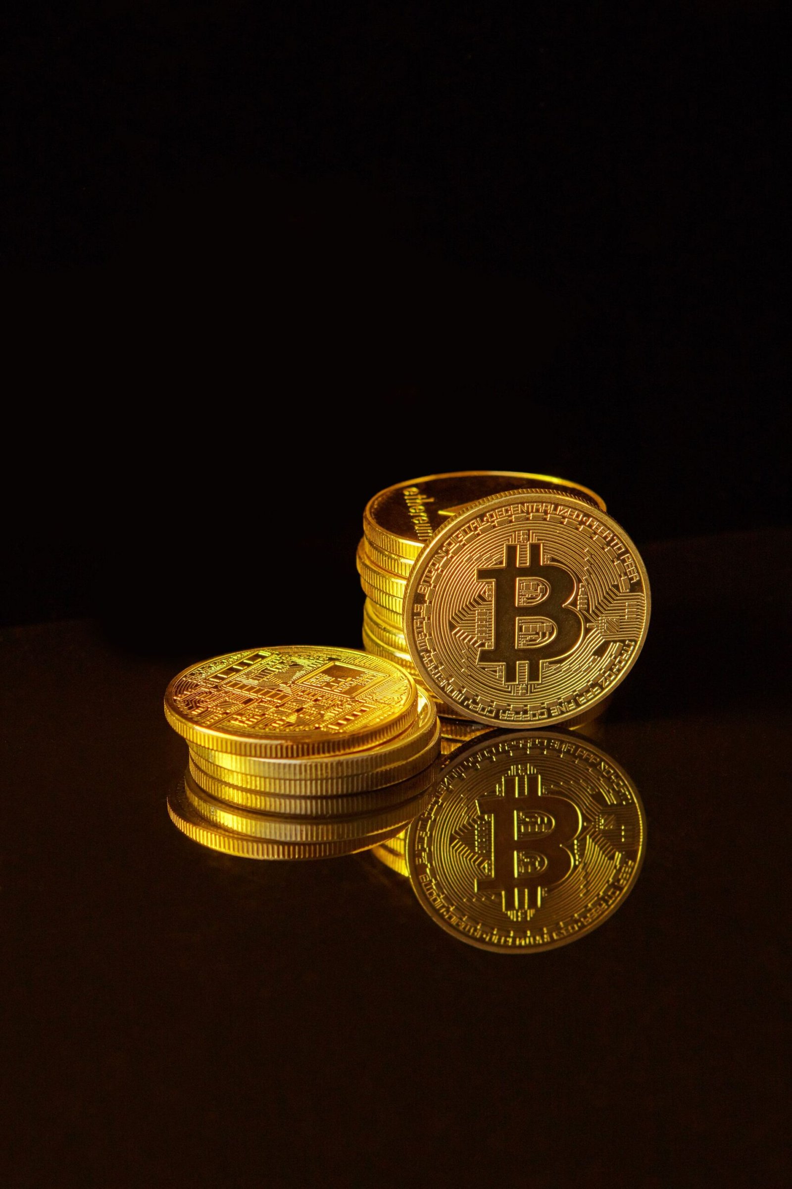 Gold and silver crypto coins on a dark reflective surface, representing airdropped and forked tokens