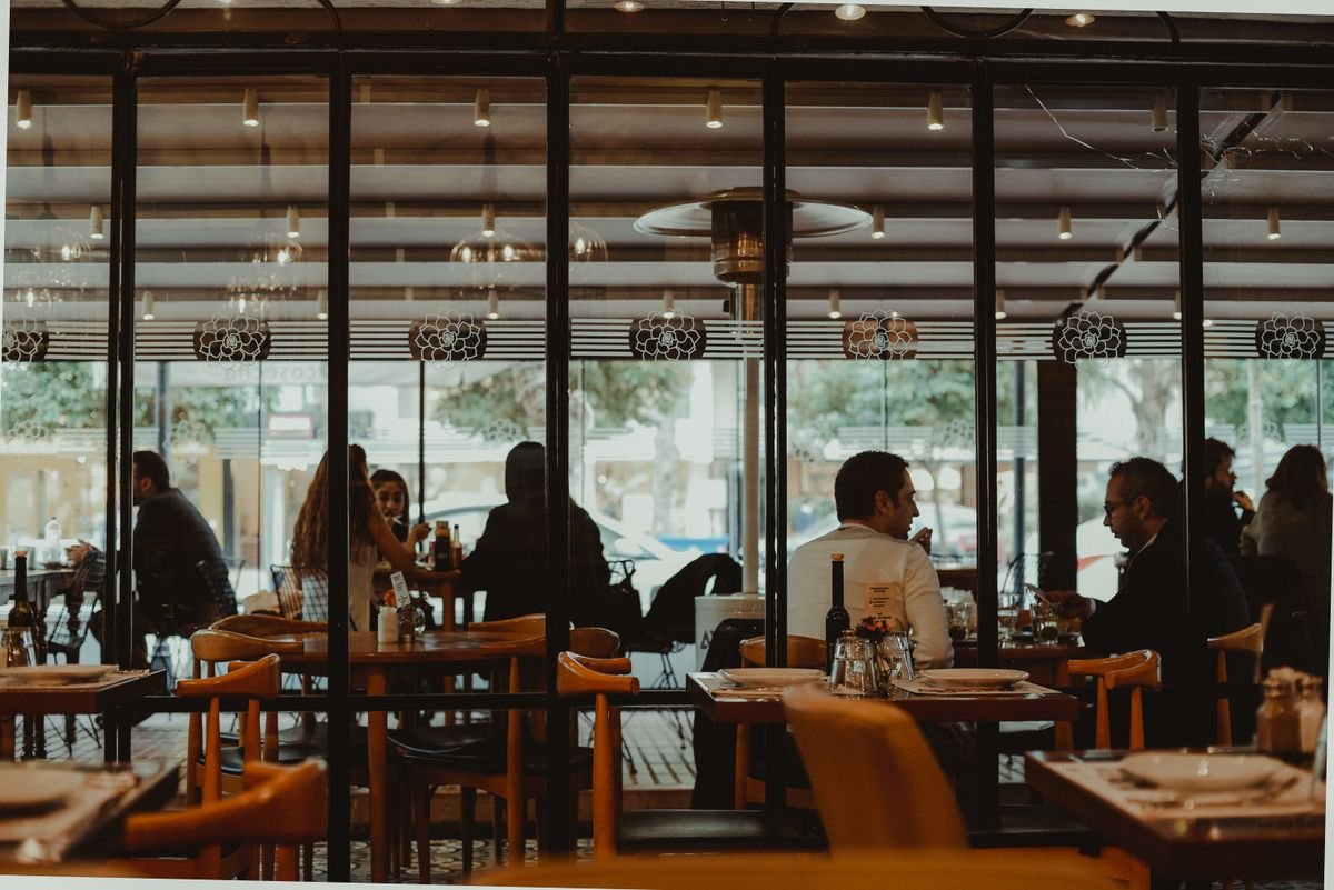 Diners in a warmly lit restaurant dining room — restaurant accounting and VAT, TaxDigit