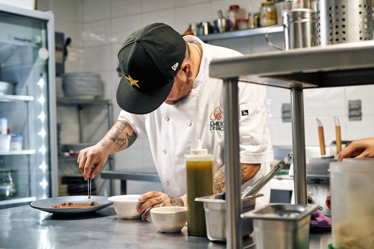 Chef plating a dish in a professional kitchen — hospitality gross margin and stock control, TaxDigit