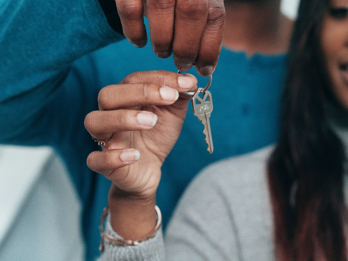 Couple holding the keys to a rental property — non-resident landlord and rental income tax, TaxDigit