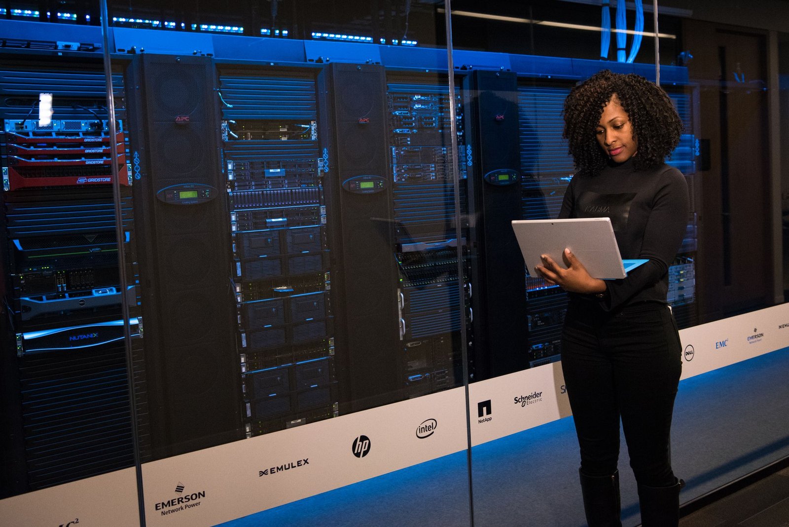 Engineer monitoring servers with a laptop in a data centre, representing running a validator node