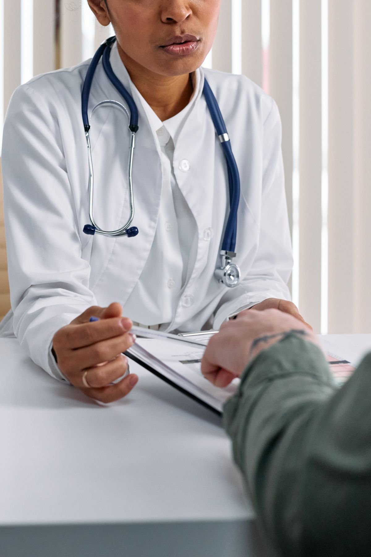 Doctor reviewing financial paperwork at a desk with a client — specialist accountants for doctors in the UK