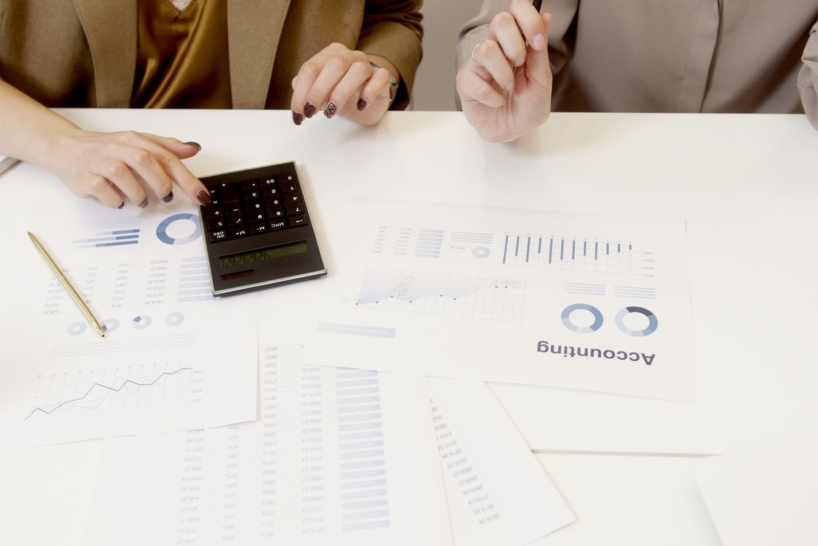 Two advisers reviewing management accounts and a calculator