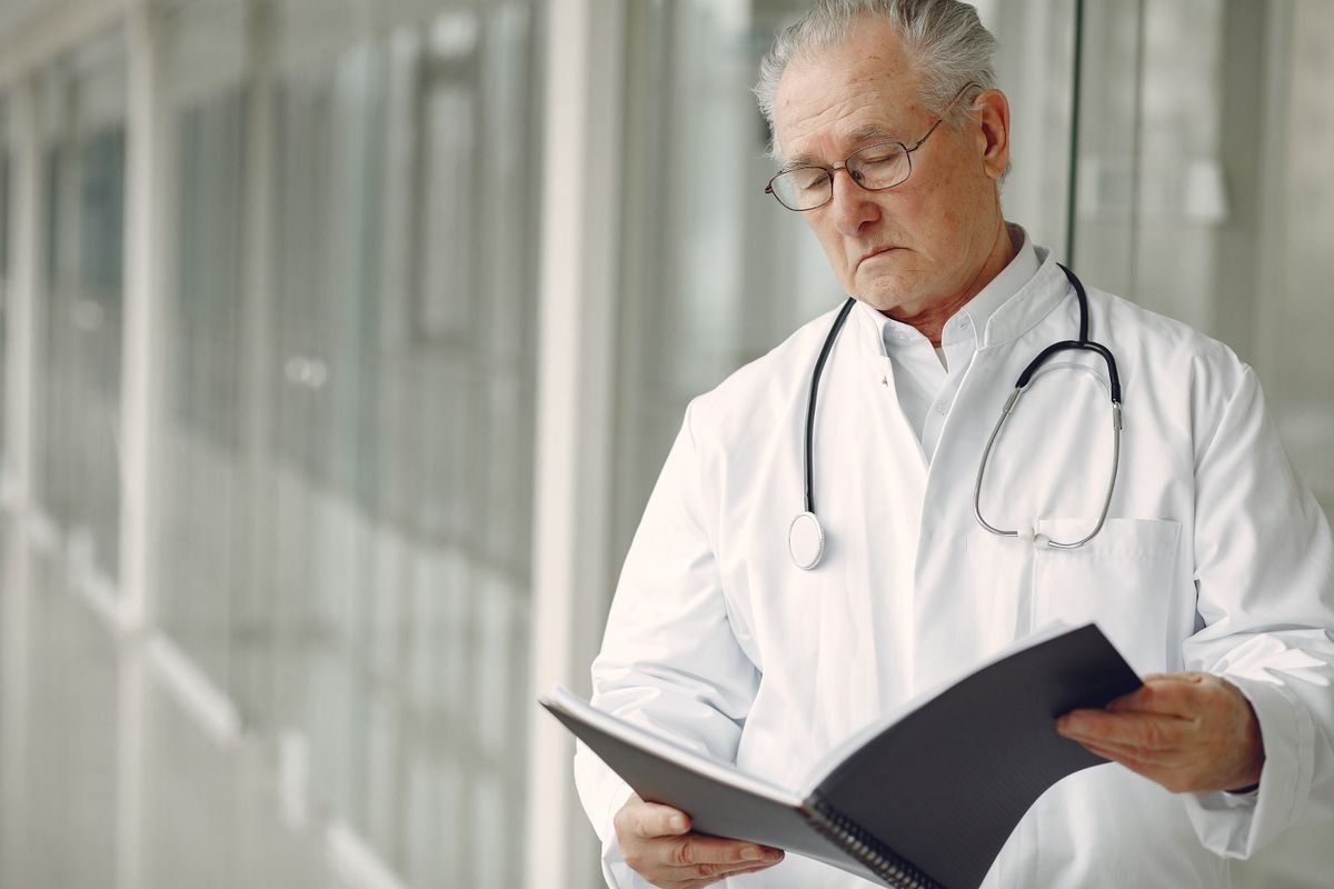 Locum doctor with a stethoscope reading a folder in a hospital corridor — accountants for locum doctors
