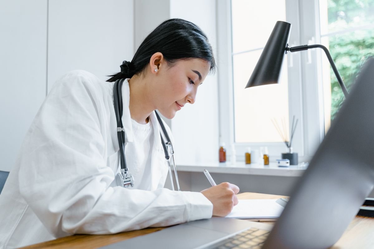 Doctor completing paperwork at a desk — NHS pension annual allowance tax advice for clinicians