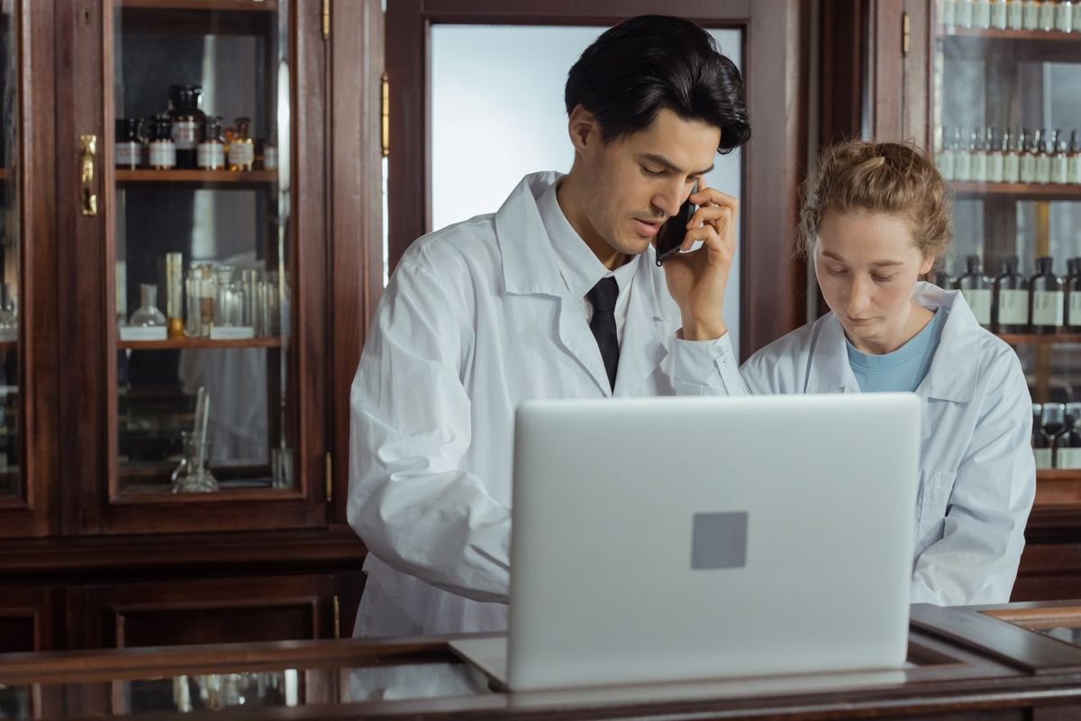 Pharmacist working at a laptop behind a pharmacy counter — specialist pharmacy accountants