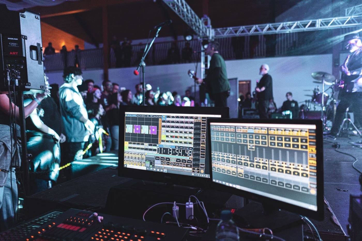 Live music performance on a concert stage with front-of-house sound engineering equipment