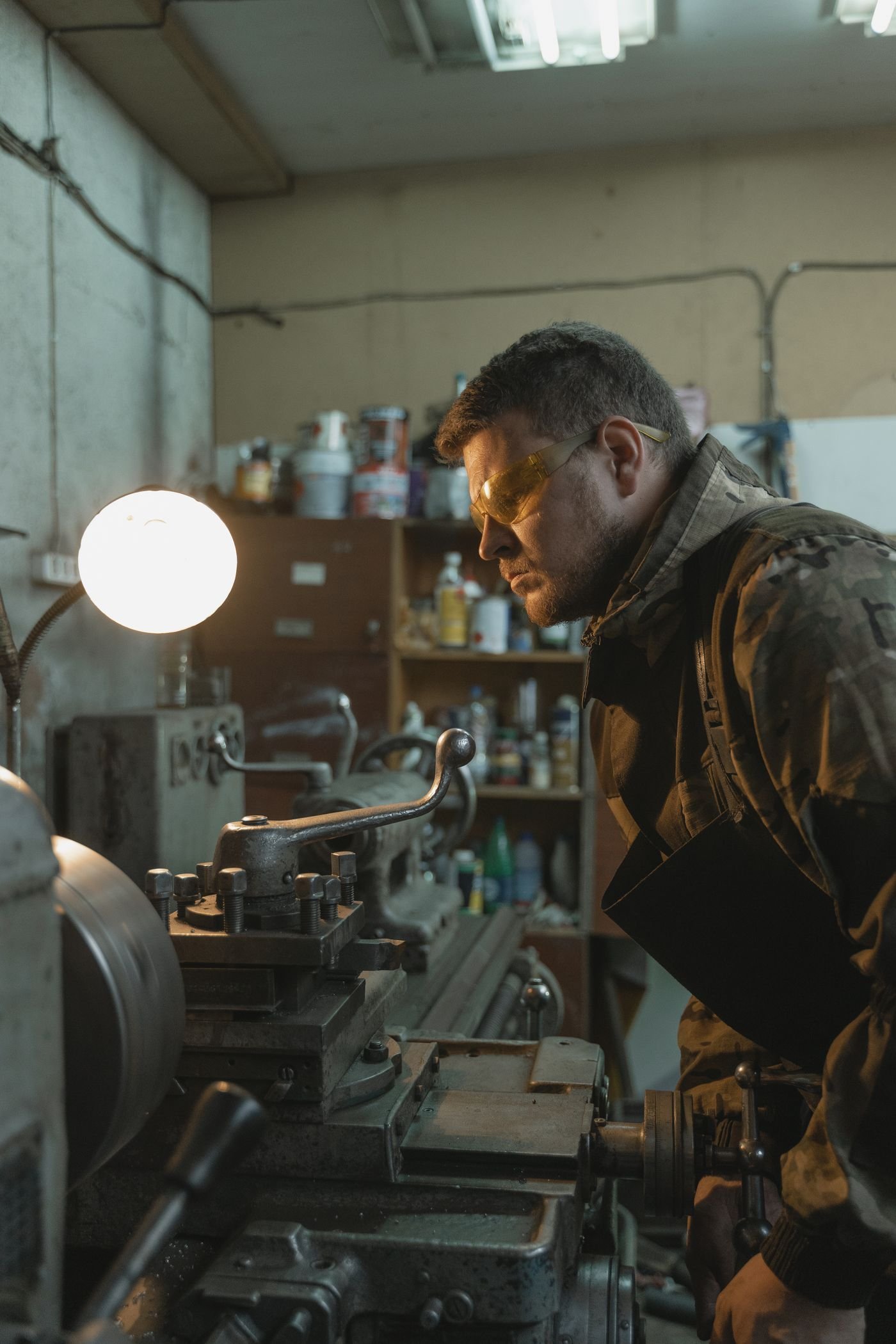 Machinist operating a metalworking lathe in a precision engineering workshop