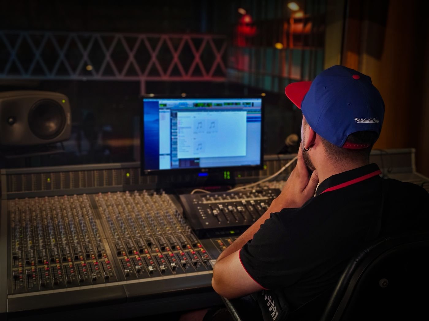 Audio engineer working at a mixing desk in a professional recording studio