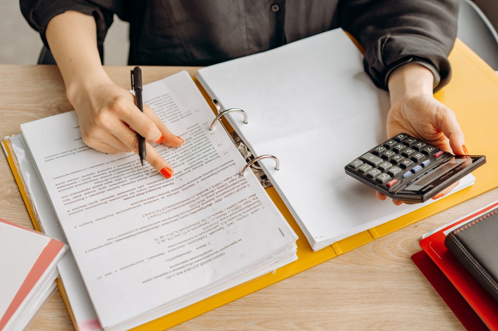 Hands working through a ledger with a calculator, rebuilding a crypto transaction history